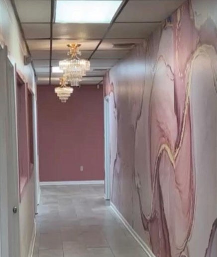 Elegant marble hallway at Beaute Kam Hair in Monroe, Louisiana, US, with chandeliers and pink decor.
