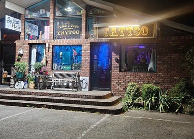 Entrance of Tony’s Tried & True Tattoo in Port Orchard, Washington, adorned with brick and neon lights.