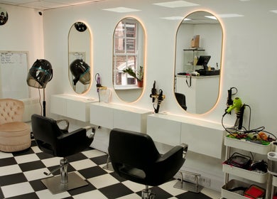 Elegant salon interior at Hey Jude, Liverpool, England, GB with chic mirrors and styling stations.