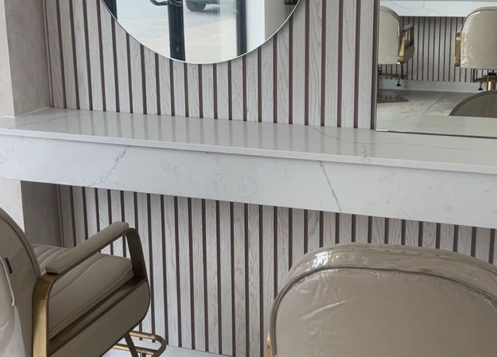Elegant salon interior at Glossed by Olivia, Northampton, England, GB, featuring stylish chairs and a round mirror.