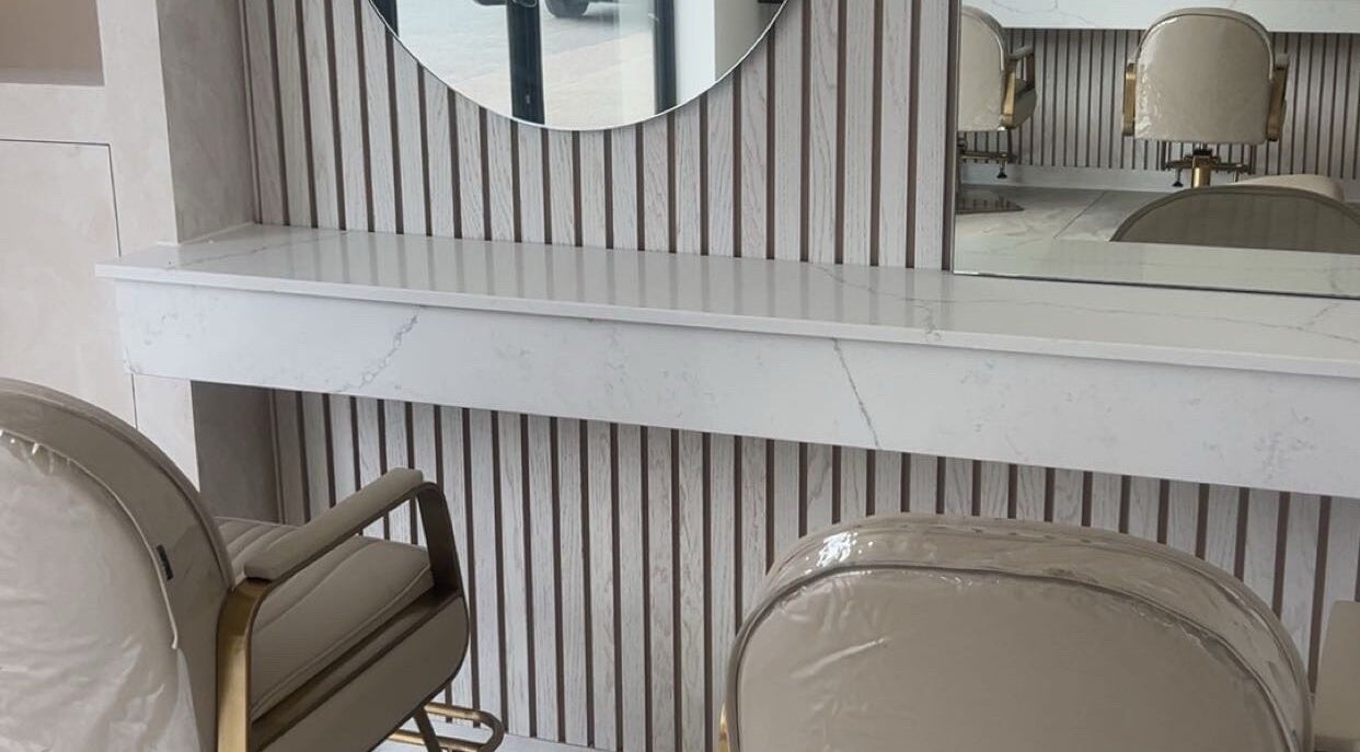 Elegant salon interior at Glossed by Olivia, Northampton, England, GB, featuring stylish chairs and a round mirror.