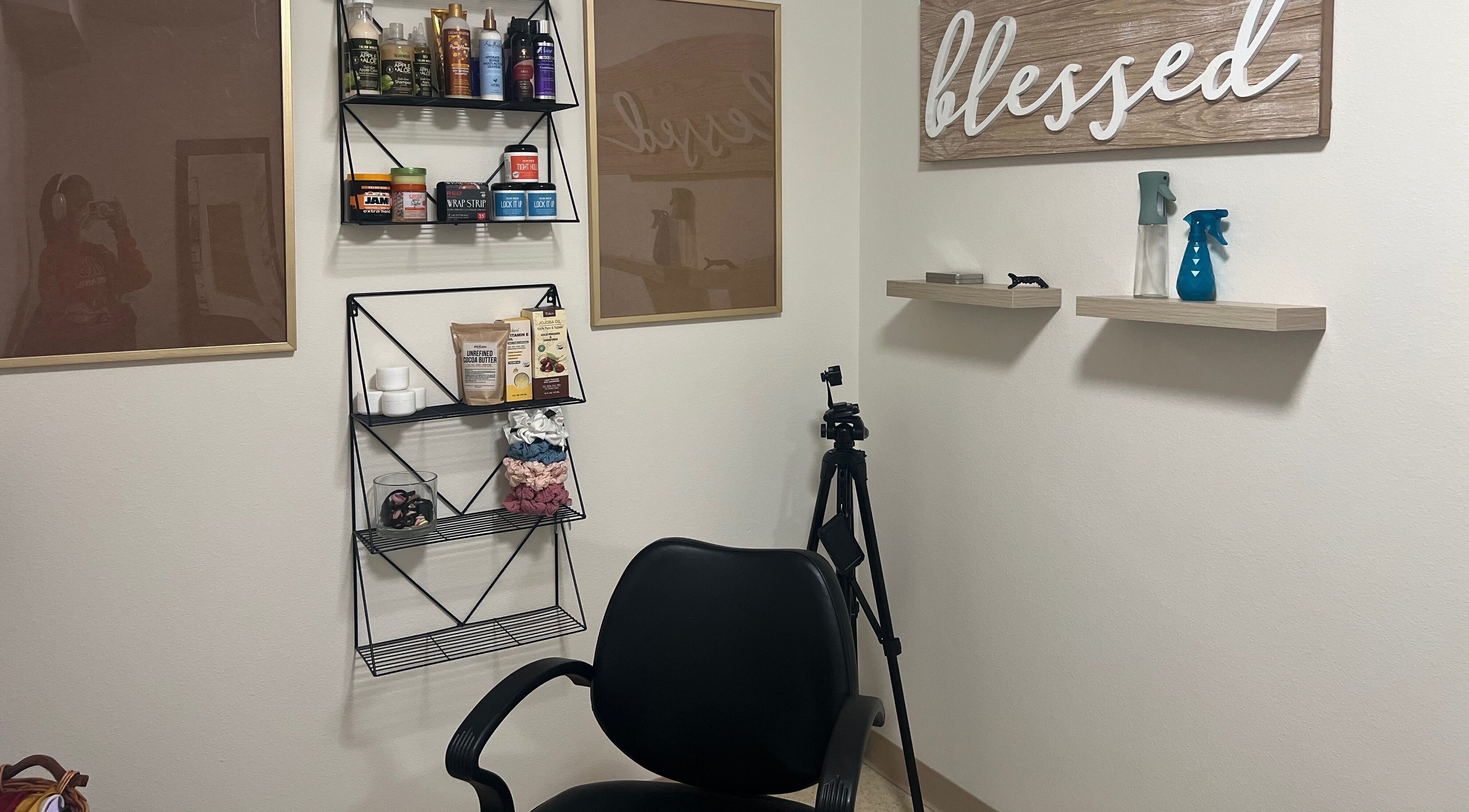 Well-stocked hair care area at Locs By KeAirya Gynene, JBER, Alaska, US showing products and seating.
