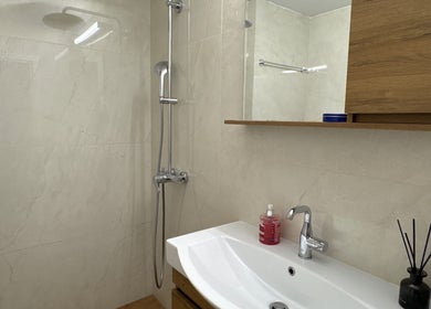 Σύγχρονο μπάνιο στο Gems Fitness Studio στην Κηφισιά, GR, με κομψό ντουζ και ξύλινο γραφείο.