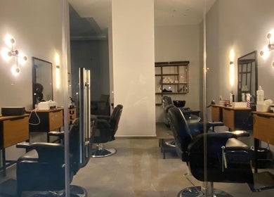 Modern barber chairs at Barber & Beauty House in Antelias, Jabal Lubnan, LB, with sleek decor and ambient lighting.