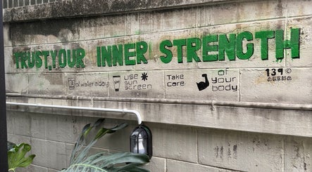 Green mural at 139Arena, Krung Thep Maha Nakhon reading 'Trust Your Inner Strength,' promoting wellness.