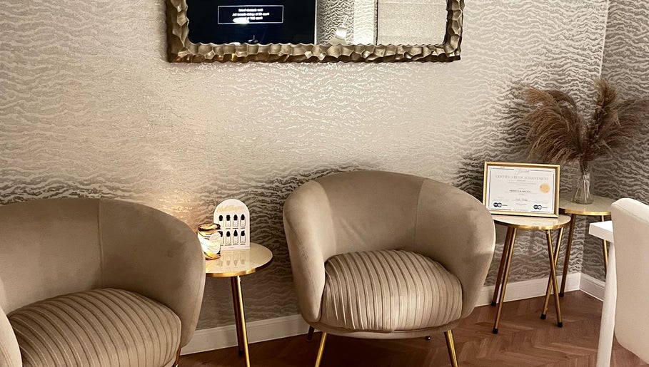 Elegant waiting area in nailsbyreb_ at Bishopbriggs, Scotland, GB with plush armchairs and gold accents.
