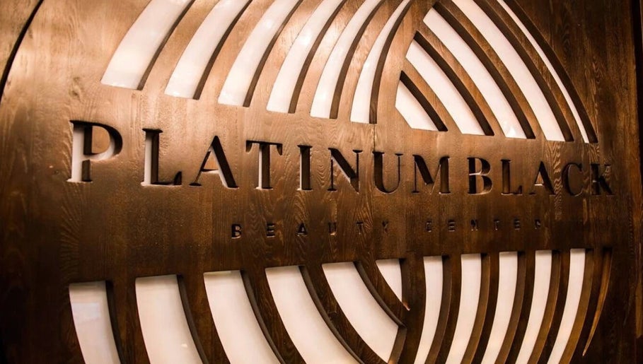 Elegant wooden signage at Platinum Black Gents Salon, Dubai, AE, featuring sleek design elements.