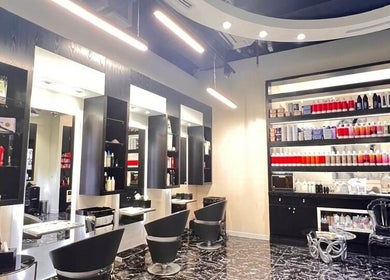 Chic interior of Platinum Black Ladies Salon in Dubai, AE with sleek styling chairs and a well-stocked product shelf.