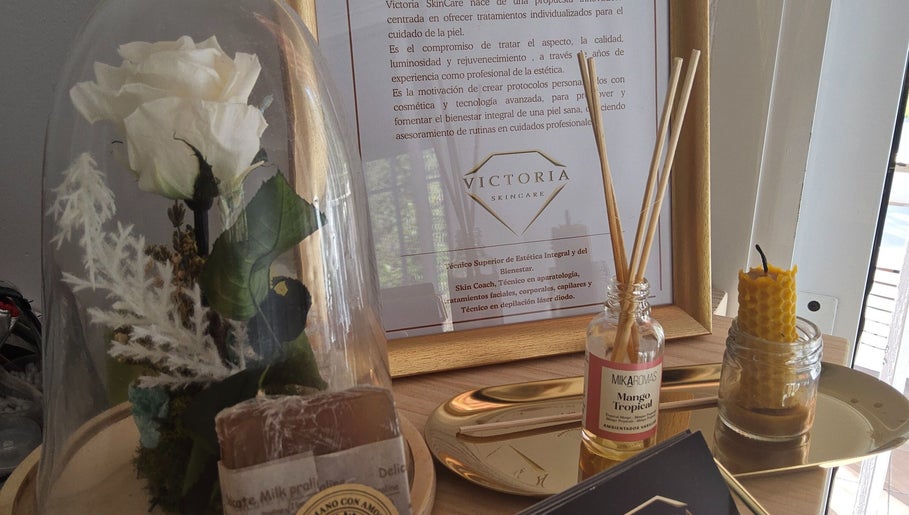 Decoración elegante en Victoria SkinCare, Aljaraque, Andalucía, ES, con flor blanca y aceites aromáticos.