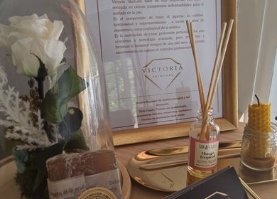 Decoración elegante en Victoria SkinCare, Aljaraque, Andalucía, ES, con flor blanca y aceites aromáticos.