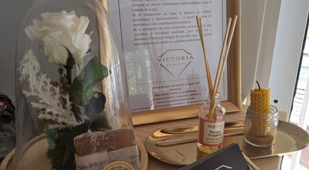 Decoración elegante en Victoria SkinCare, Aljaraque, Andalucía, ES, con flor blanca y aceites aromáticos.