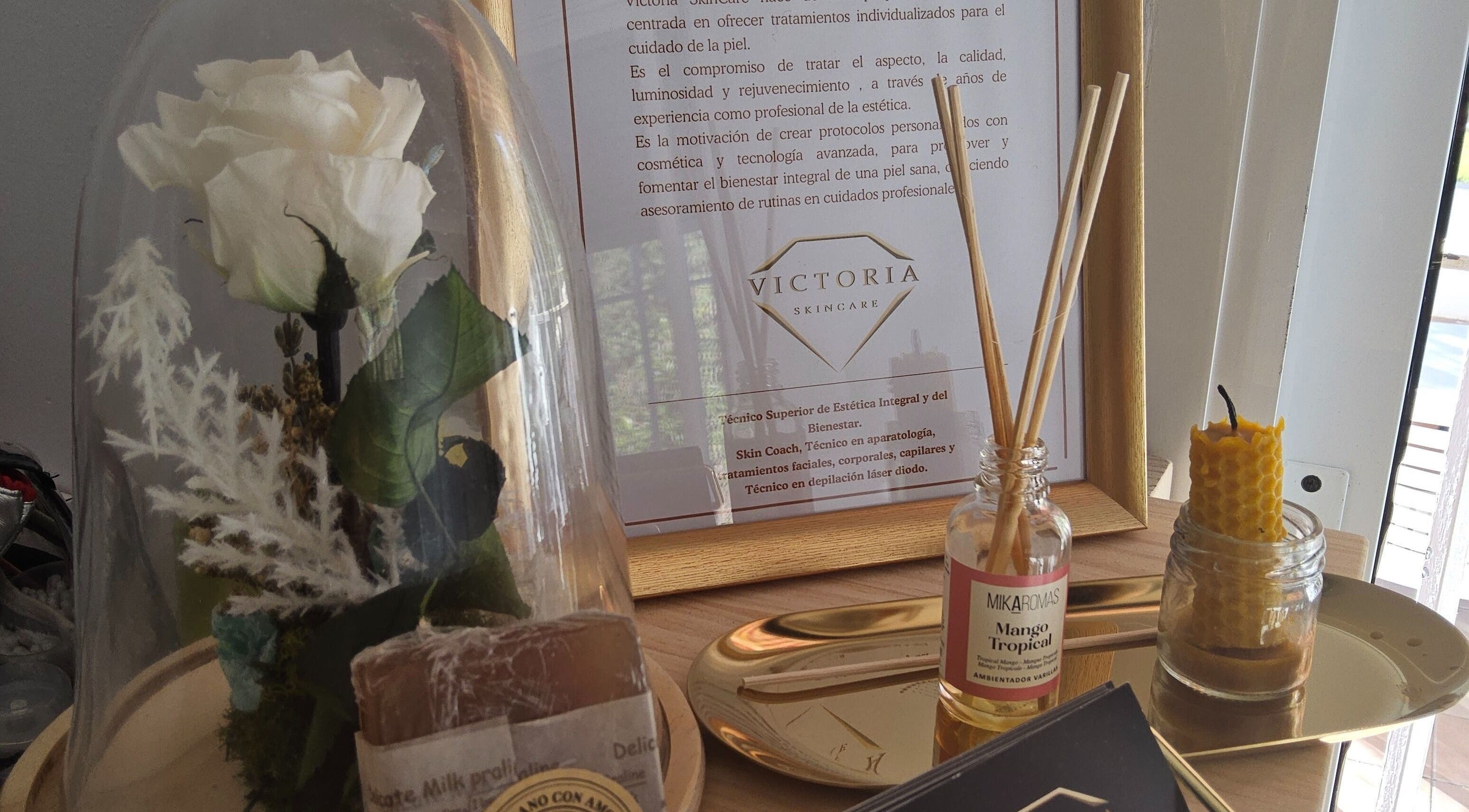 Detalles elegantes de Victoria SkinCare en Aljaraque, Andalucía, ES, con flor blanca bajo campana de cristal.