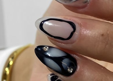 Manicura artística en Club Bae, Las Condes, Región Metropolitana, CL. Diseño en blanco y negro con detalles brillantes.