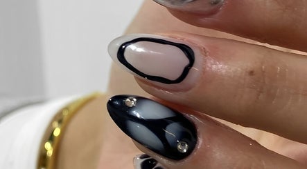 Manicura artística en Club Bae, Las Condes, Región Metropolitana, CL. Diseño en blanco y negro con detalles brillantes.