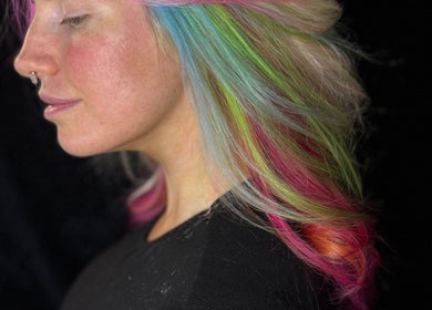 Vibrant rainbow hair styled at Friel Good Hair, Glasgow, Scotland, GB. Side profile showcasing multicolored strands.