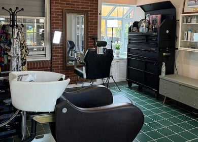 Intérieur moderne du salon Maison Barbier Lachute, Lachute, Québec, CA, avec fauteuil de barbier et lavabo.