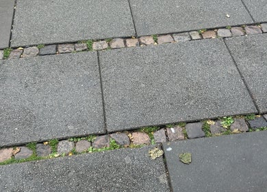 Elegant stenbelægning uden for Vallarelli Cuts, Aarhus, DK, skaber en indbydende indgang.