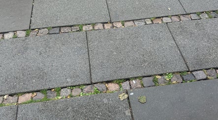 Elegant stenbelægning uden for Vallarelli Cuts, Aarhus, DK, skaber en indbydende indgang.