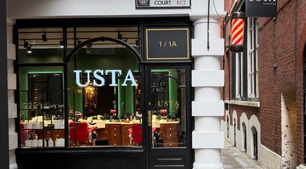 Front view of Usta Barbers, a chic barbershop in London, England, GB. Display windows and classic decor feature.
