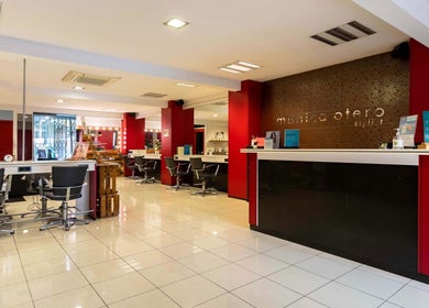 Salón luminoso de Monica Otero Stylist en Cornellà De Llobregat, Catalunya, ES, con sillas modernas y decoración roja.