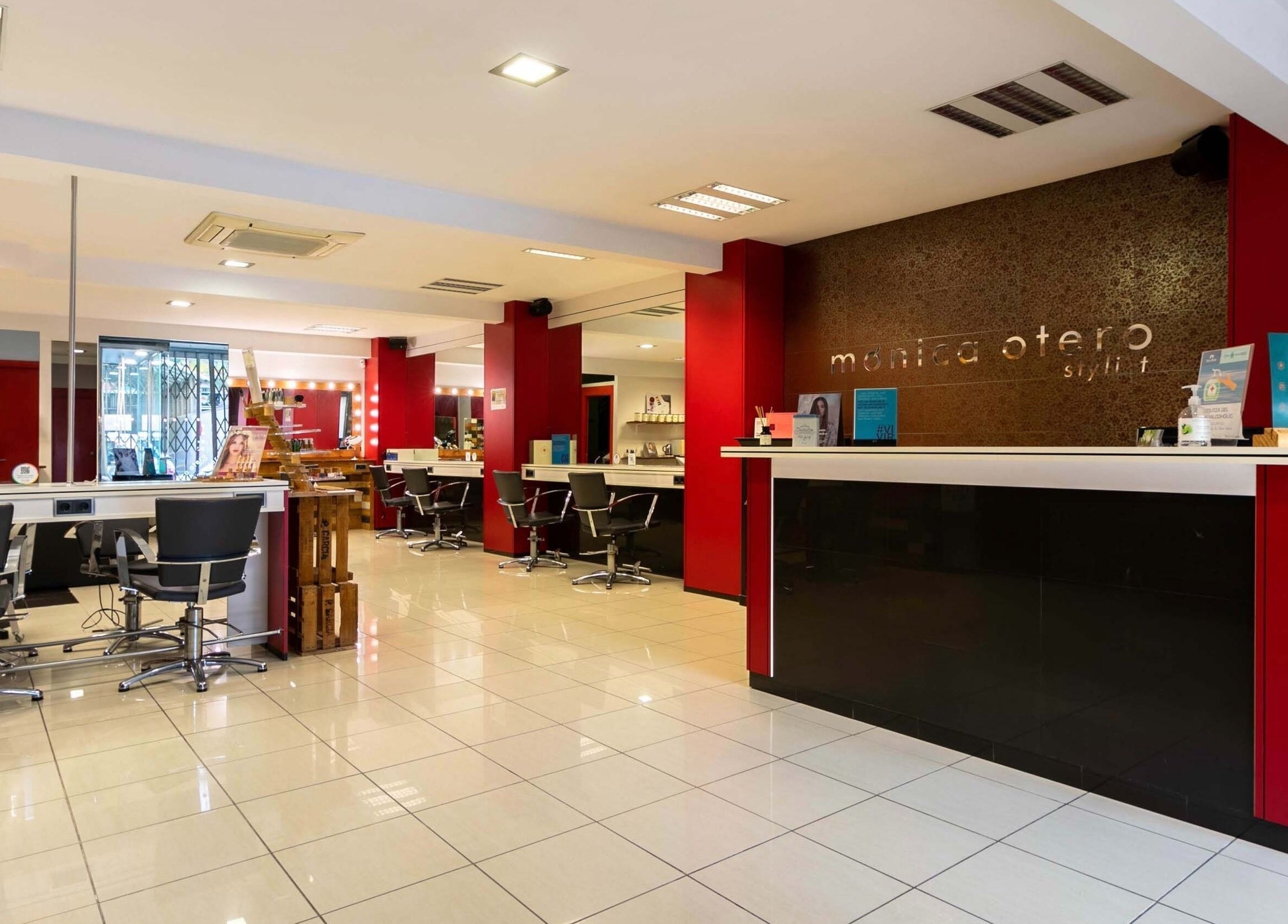 Salón luminoso de Monica Otero Stylist en Cornellà De Llobregat, Catalunya, ES, con sillas modernas y decoración roja.