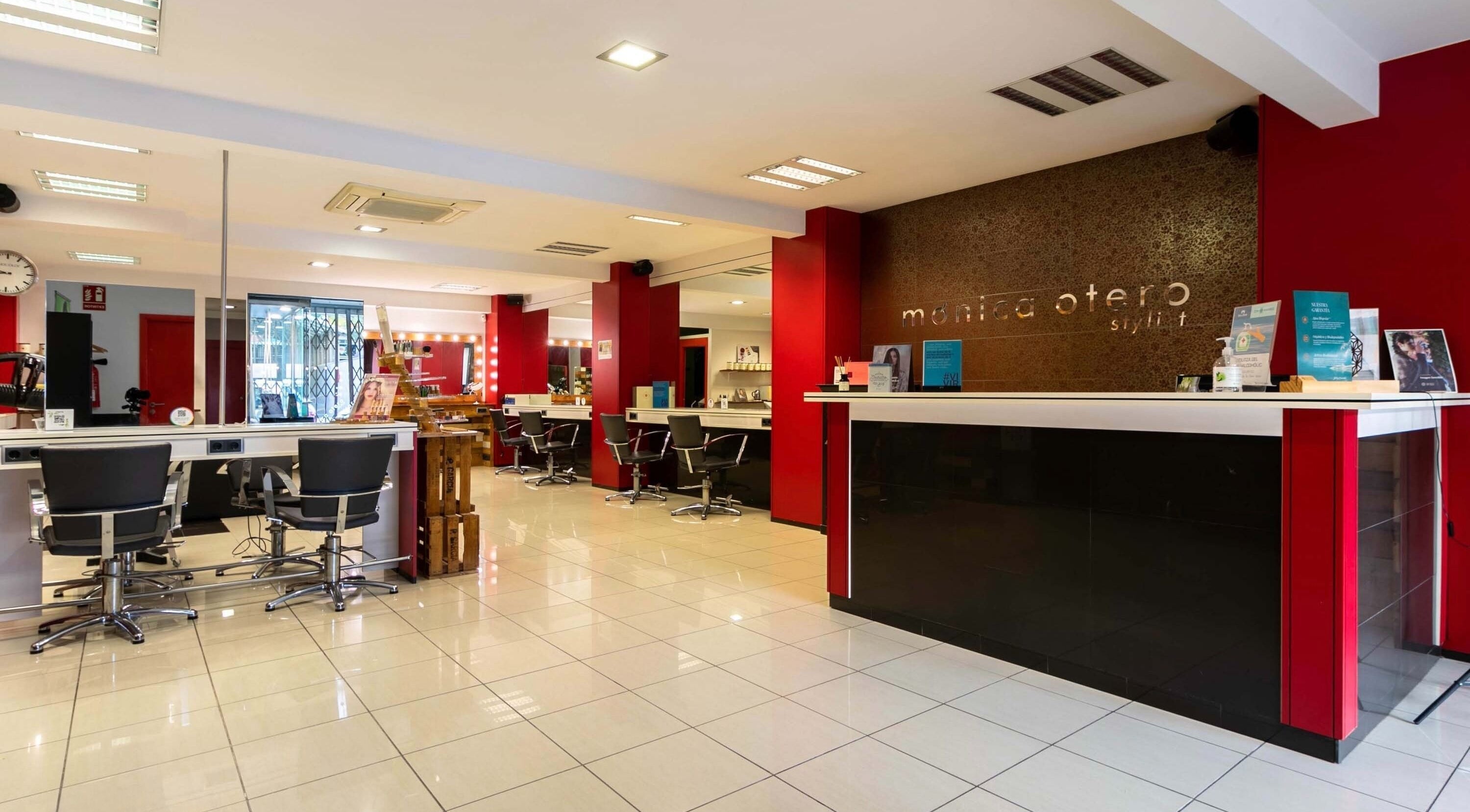 Salón luminoso de Monica Otero Stylist en Cornellà De Llobregat, Catalunya, ES, con sillas modernas y decoración roja.