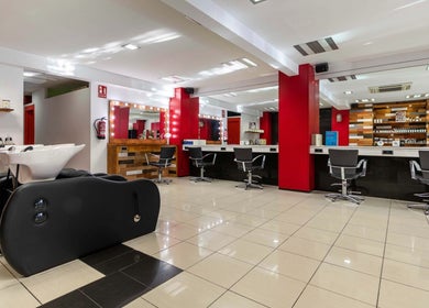 Interior del salón Monica Otero Stylist en Cornellà De Llobregat, Catalunya, ES, con sillas y estaciones de peinado modernas.