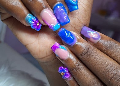 Vibrant floral nail art design at Rachella Creations, Oistins, Christ Church, BB. Stunning blue and purple hues.