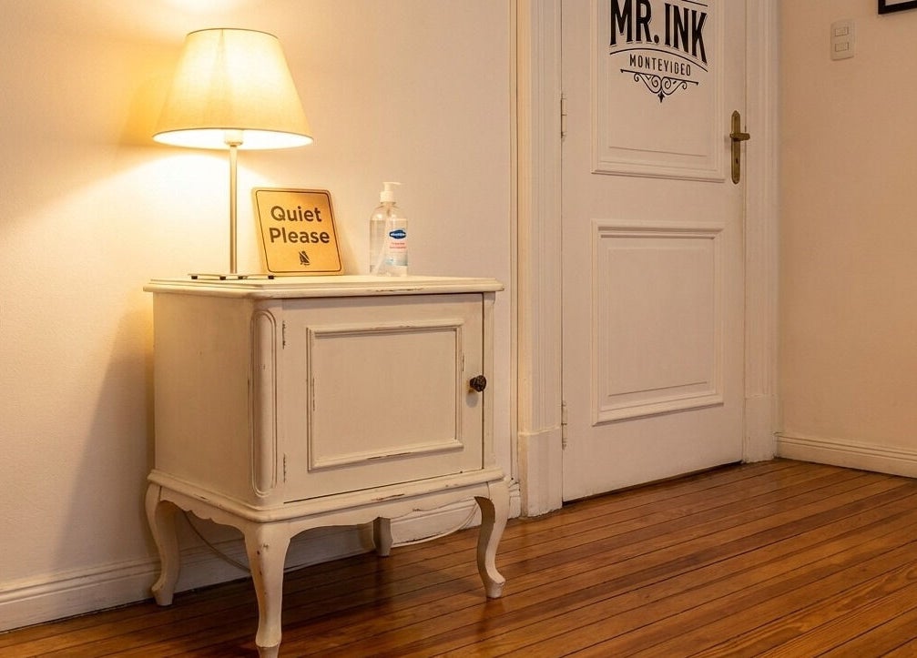 Cozy corner at ETHEREAL INK BODY ART, Brant, Ontario, CA with lamp and quiet please sign on a vintage cabinet.