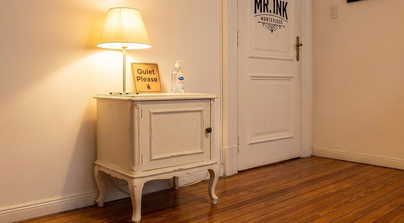 Cozy corner at ETHEREAL INK BODY ART, Brant, Ontario, CA with lamp and quiet please sign on a vintage cabinet.