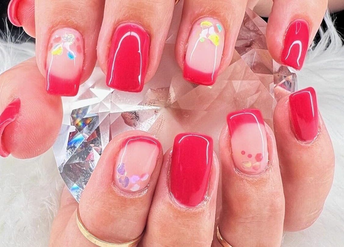 Vibrant red nail art with floral accents at Bougie Nails with G, Santa Maria, California, US.