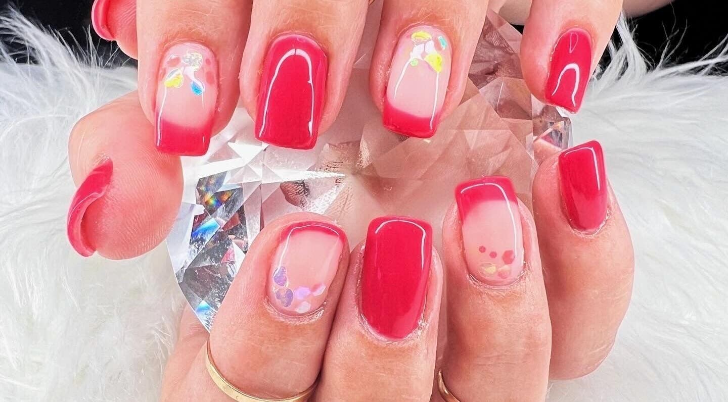 Vibrant red nail art with floral accents at Bougie Nails with G, Santa Maria, California, US.