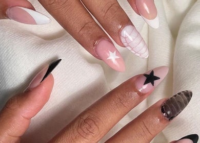 Stylish star-themed nail art at Cured in Cambridge, England, GB, showcasing intricate design details.