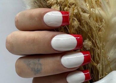 Red-tipped manicured nails at Cured, Cambridge, England, GB showcasing stylish nail art.