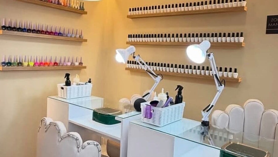Estación de manicura en Elite Barber Nails, Envigado, Antioquia, CO, decorada con esmaltes coloridos.