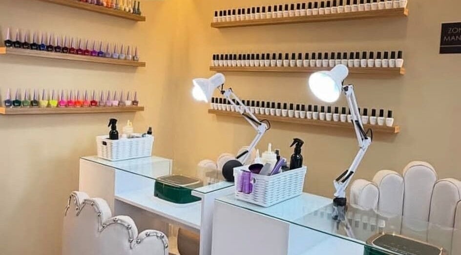 Estación de manicura en Elite Barber Nails, Envigado, Antioquia, CO, decorada con esmaltes coloridos.