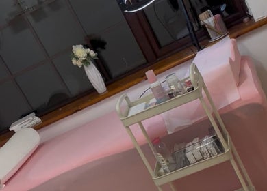 Treatment bed at Bare Beauty by Hannah, Clane, County Kildare, IE, with pink decor and beauty supplies.