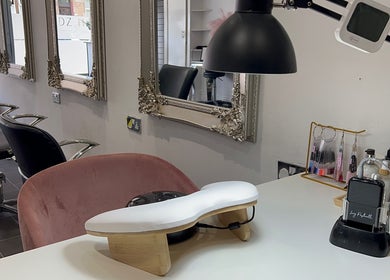 Chic nail station at HT Studio in Glasgow with plush seating and ornate mirrors.