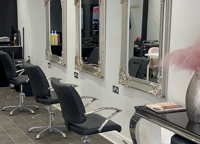 Elegant salon interior with mirrors and styling chairs at HT Studio, Glasgow, Scotland, GB.