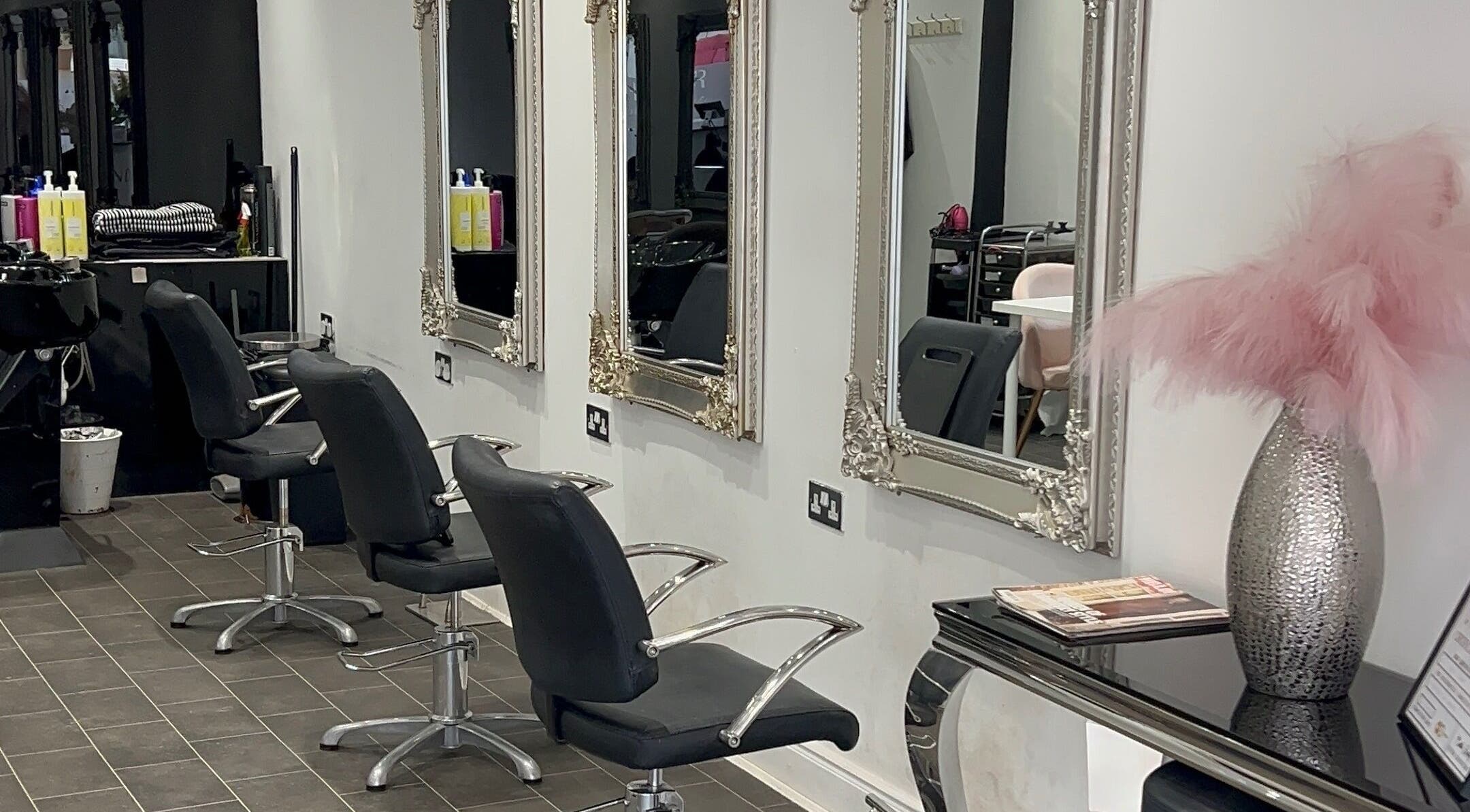 Elegant salon interior with mirrors and styling chairs at HT Studio, Glasgow, Scotland, GB.