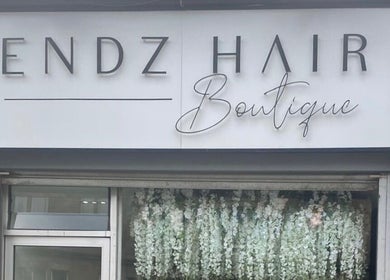 Exterior of HT Studio in Glasgow, Scotland, GB showcasing a floral display beneath the boutique's signage.