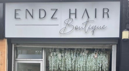 Exterior of HT Studio in Glasgow, Scotland, GB showcasing a floral display beneath the boutique's signage.