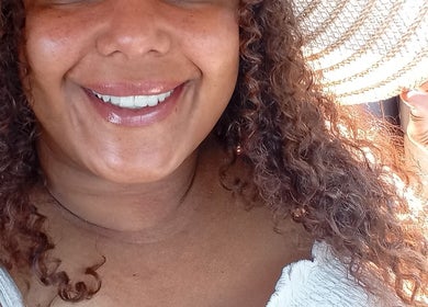 A woman smiling radiantly in the sunshine at Nail2yubyjayy, Chicago, Illinois, US.