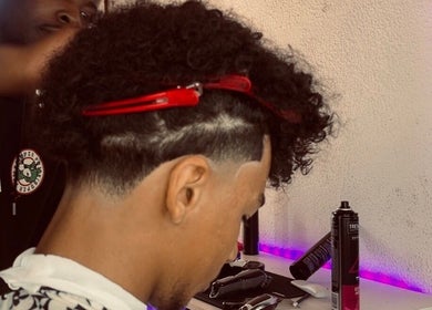 Hair stylist at Faded By Emmy in Cape Town, Western Cape, ZA giving a stylish haircut with precision and care.