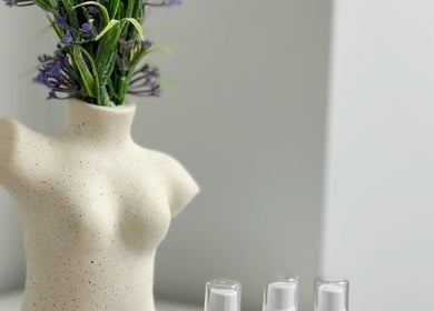 Minimalist vase with purple flowers and beauty products at Glam Lashes NYC, New York, New York, US.