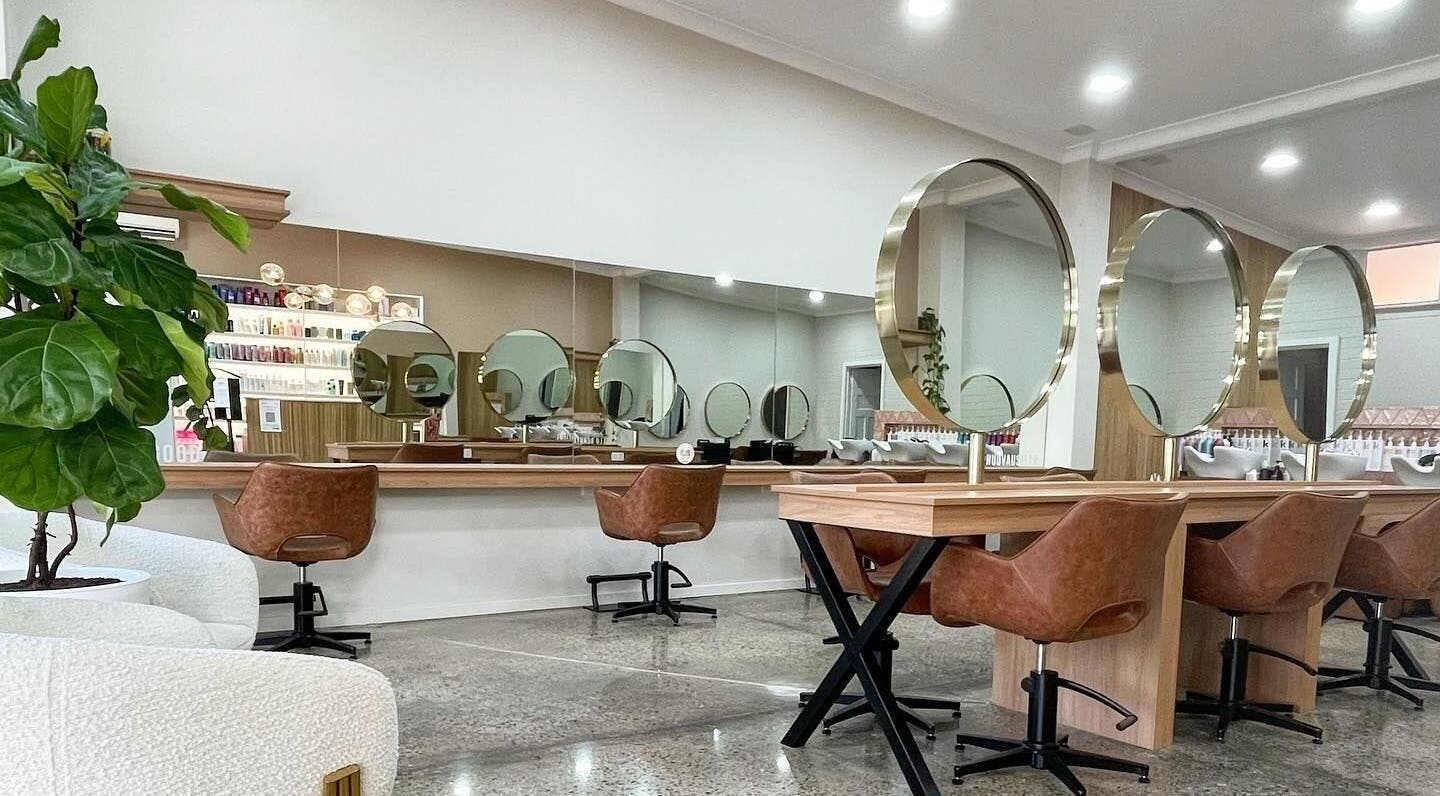 Elegant salon interior with round mirrors at Nuova U Salon, Mount Pleasant, Western Australia, AU.