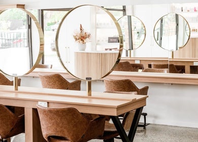 Sleek salon interior with circular mirrors at Nuova U Salon, Mount Pleasant, Western Australia, AU.