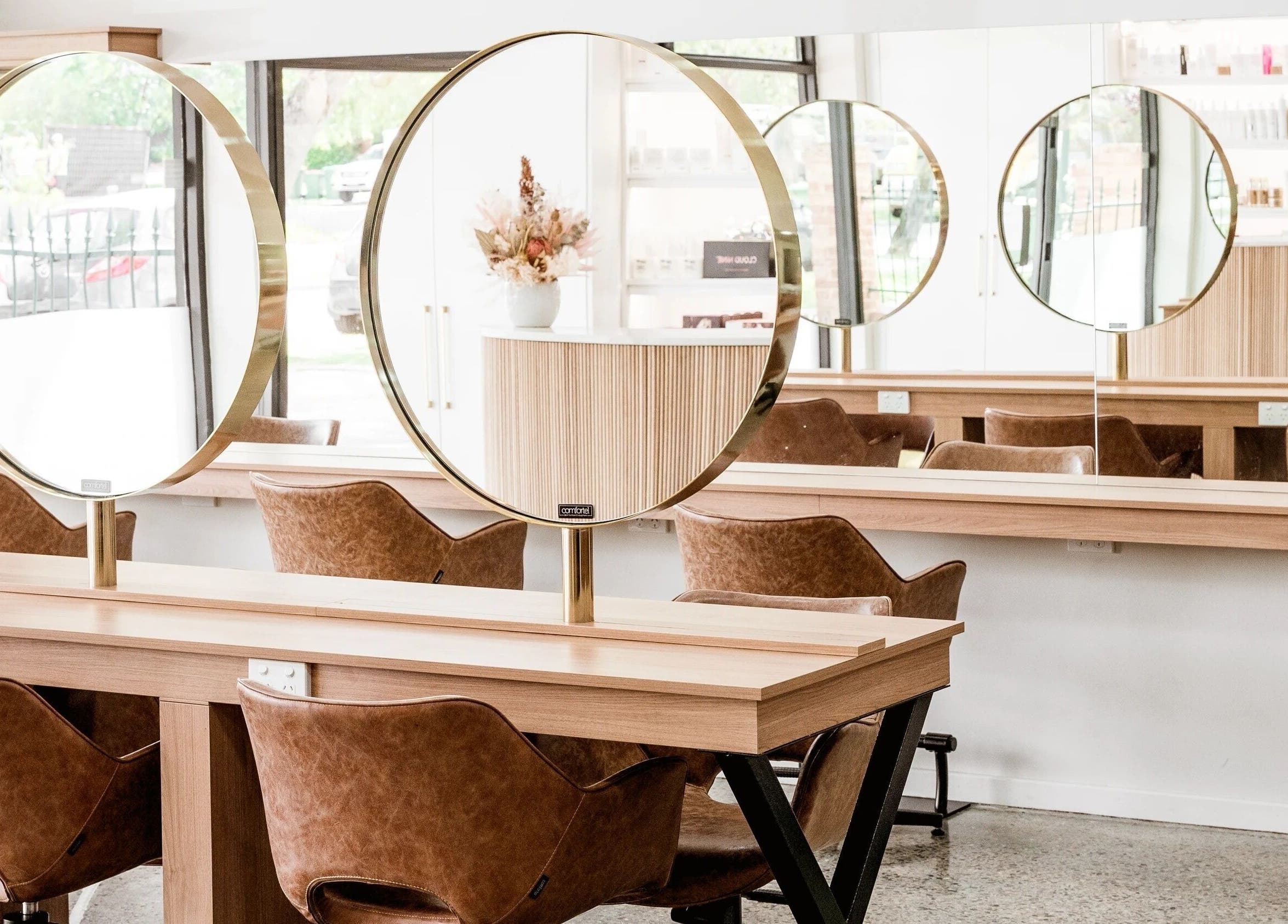 Sleek salon interior with circular mirrors at Nuova U Salon, Mount Pleasant, Western Australia, AU.