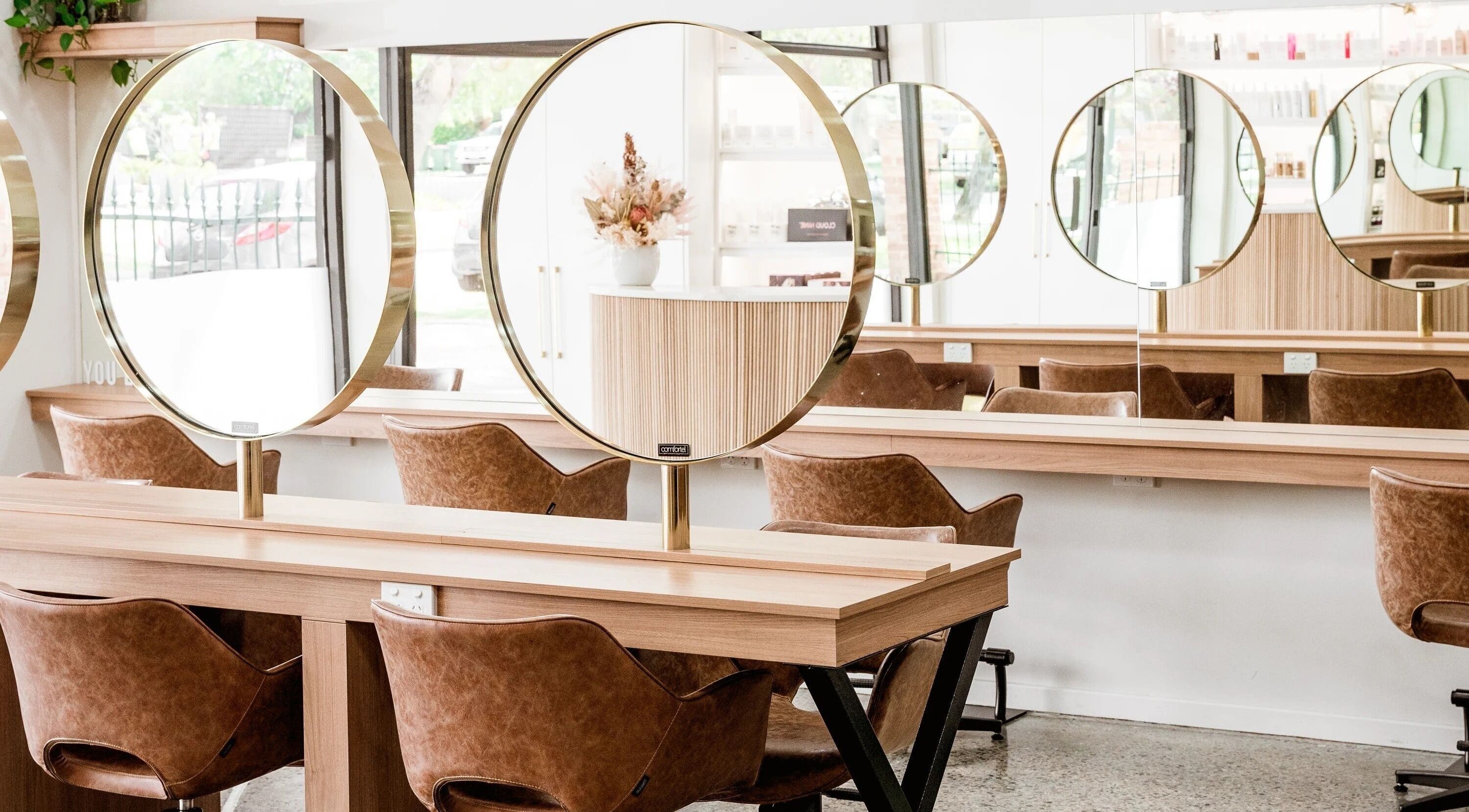Sleek salon interior with circular mirrors at Nuova U Salon, Mount Pleasant, Western Australia, AU.