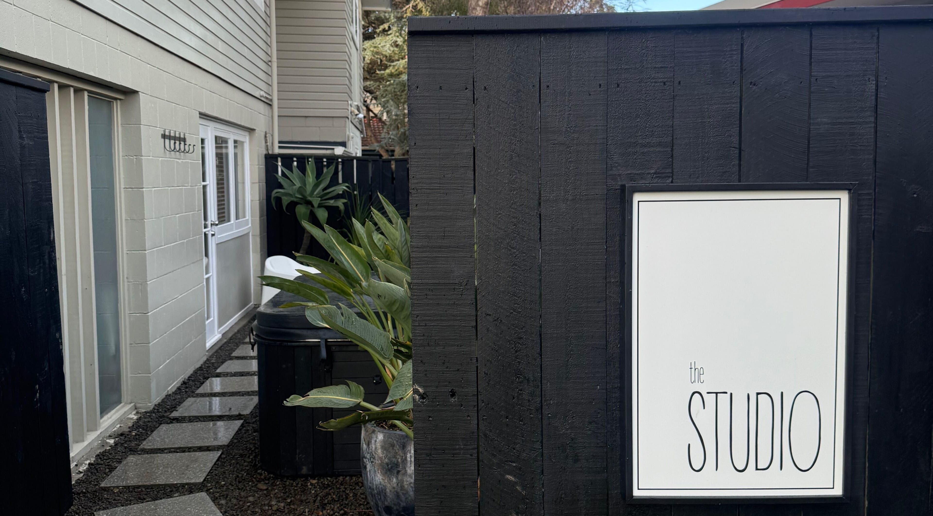Entrance of The Studio at Paraparaumu Beach, Wellington Region, NZ with plants lining the path.